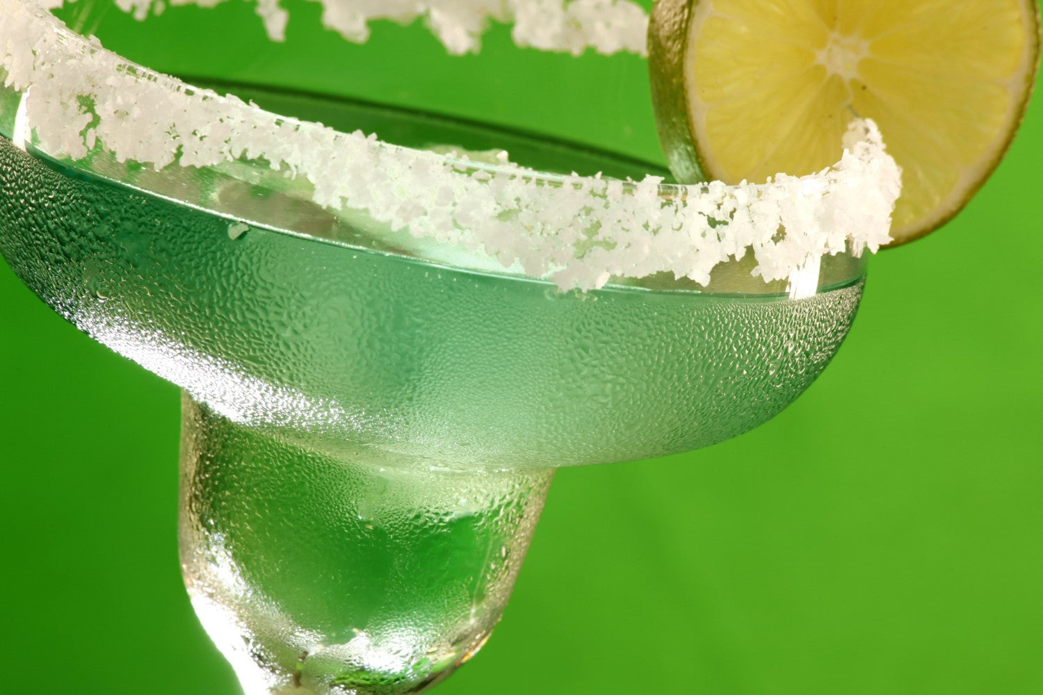 Pitcher margaritas with SALTOPIA TWISTED SISTAZ lemon lime salt rim, garnished with lime wedges